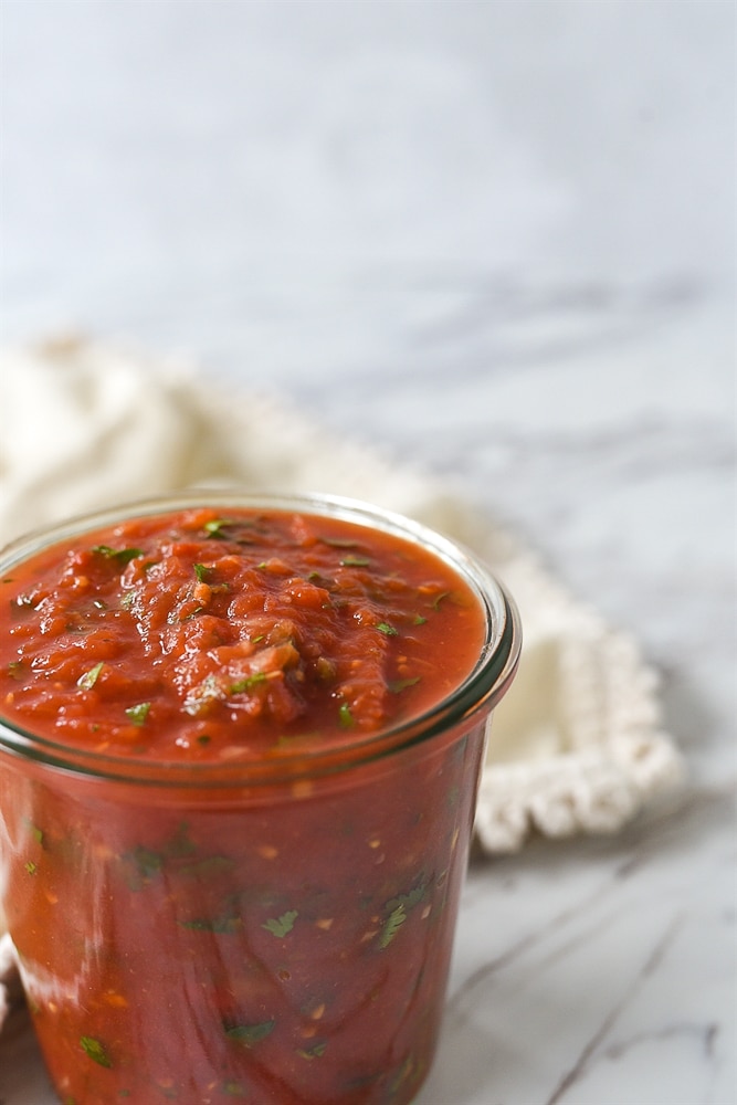 salsa maker squeezes tomatoes to produce traditional home-made sauce